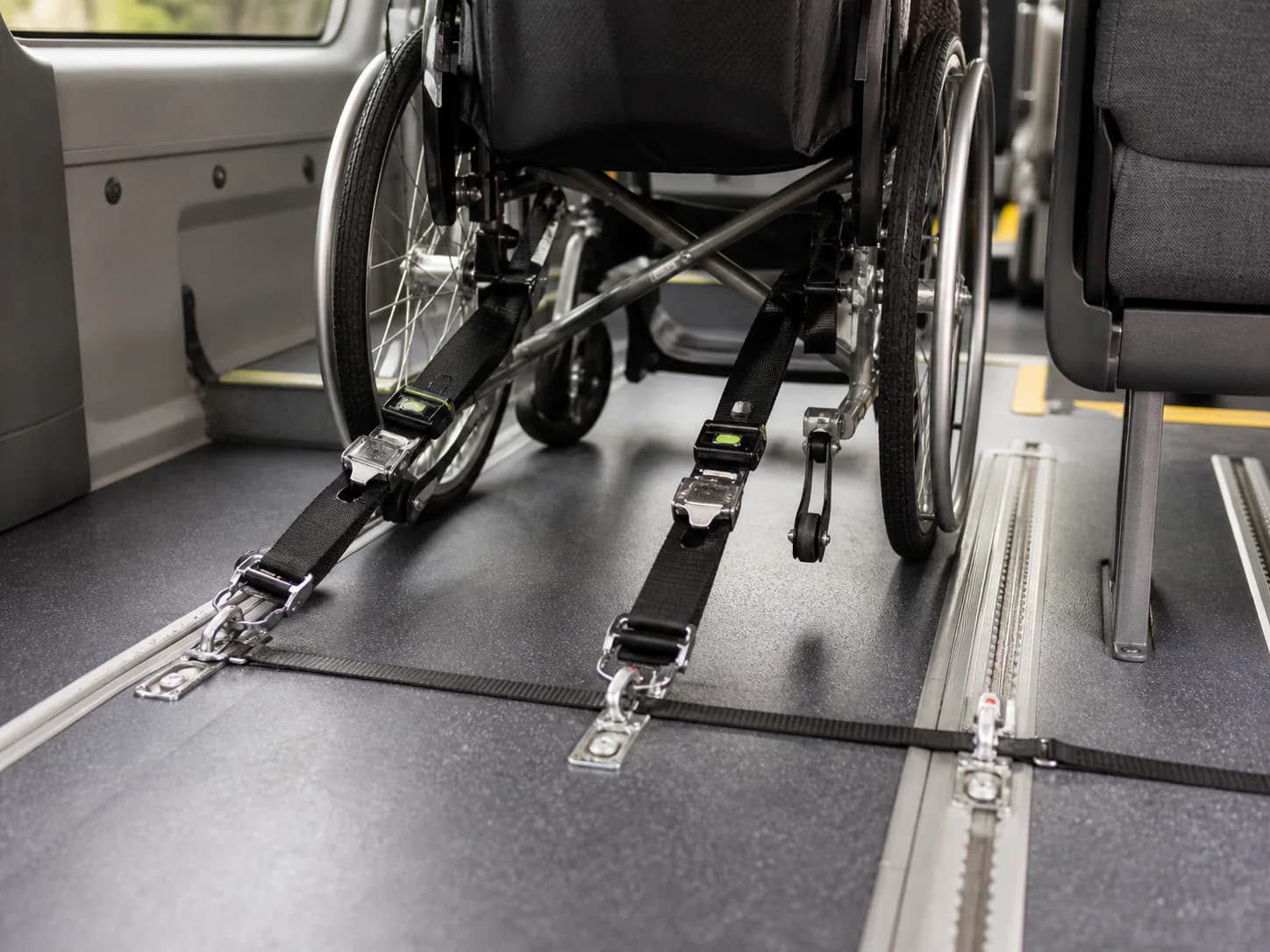 Four-point wheelchair restraints secured to the floor tracking inside a Ufirst vehicle